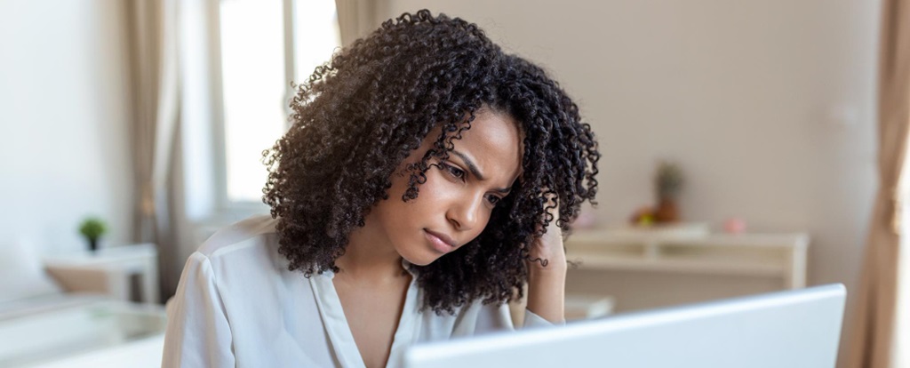 une femme devant son ordinateur semblant faire la tête