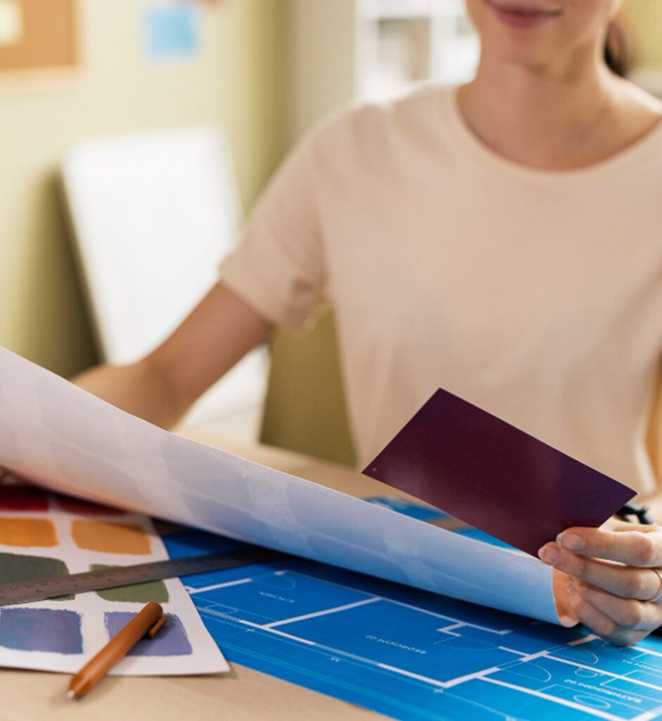 une femme à son bureau regardant des éléments de décoration d'intérieur