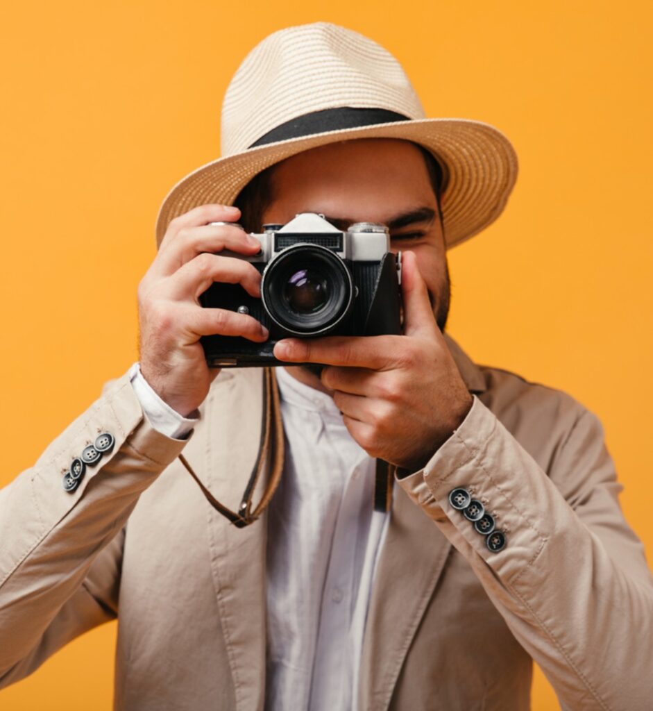 un photographe avec un chapeau prenant une photo