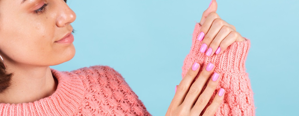 une femme avec des ongles roses