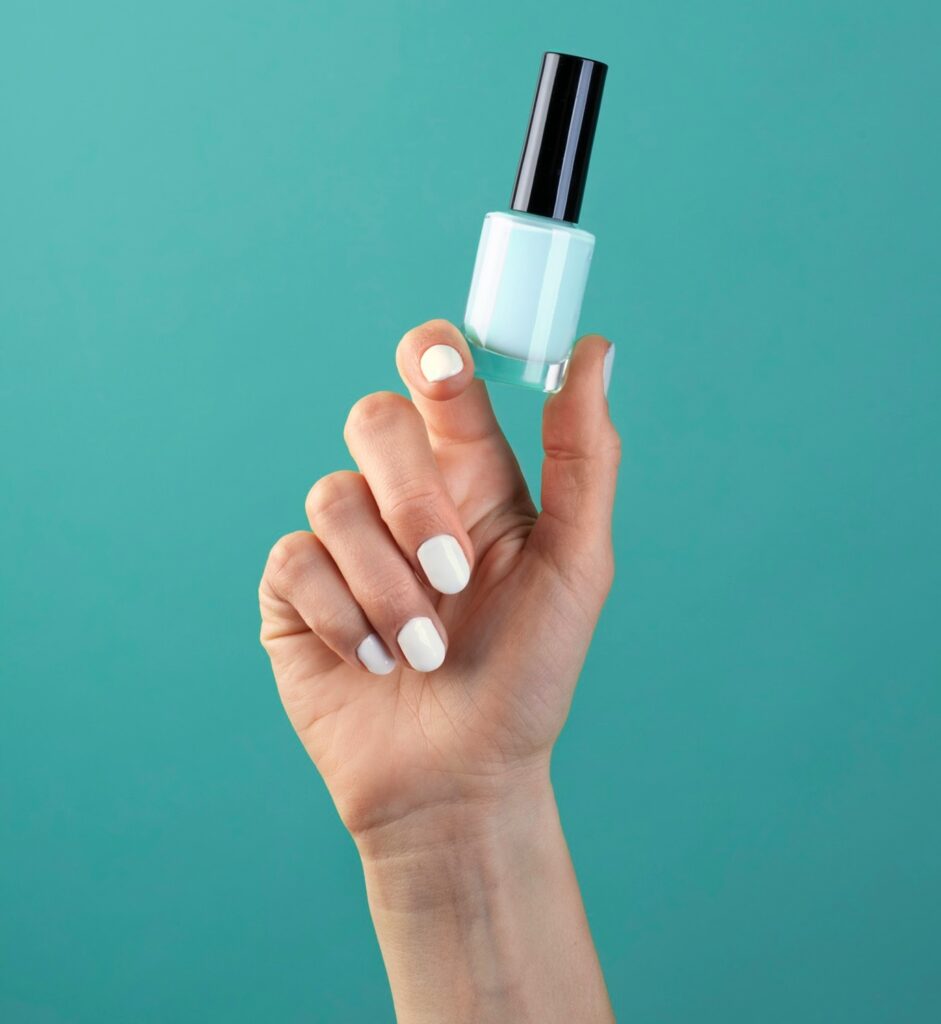 une main montrant un tube de vernis à ongles